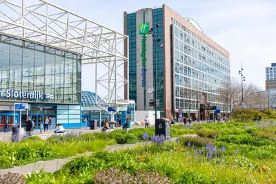 a group of buildings in a city with flowers at Holiday Inn Express Amsterdam - Sloterdijk Station by IHG in Amsterdam