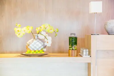 a table with a vase with flowers and a plate of fruit at Holiday Inn Express Amsterdam - Sloterdijk Station by IHG in Amsterdam