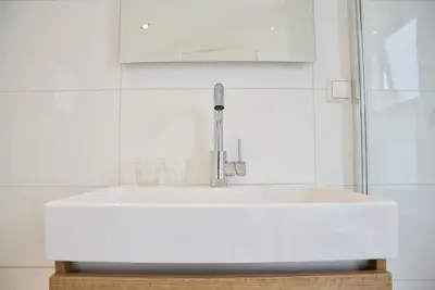 a white sink in a bathroom with a mirror at Het Torentje aan de IJssel in Montfoort