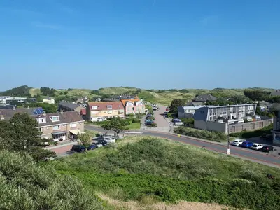 a view of a small town with a street at Duinnachtegaal in Egmond aan Zee