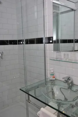 a bathroom with a glass sink and a mirror at Hotel Keistad in Amersfoort