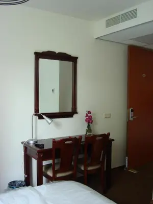 a bedroom with a desk and a mirror and a bed at Hotel Keistad in Amersfoort