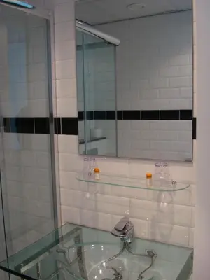 a bathroom with a glass sink and a mirror at Hotel Keistad in Amersfoort