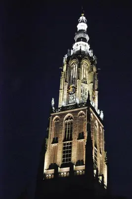 a tall tower with a clock on it at night at Hotel Keistad in Amersfoort