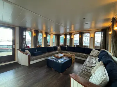 a living room with a couch and a table at Hotelboat Iris in Amsterdam