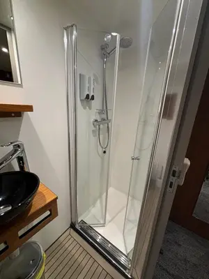 a shower with a glass door in a bathroom at Hotelboat Iris in Amsterdam