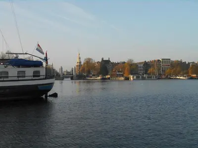 a boat in the water with a city in the background at Hotelboat Iris in Amsterdam