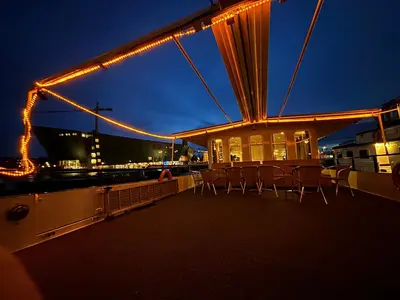 a group of chairs sitting on the deck of a boat at night at Hotelboat Iris in Amsterdam