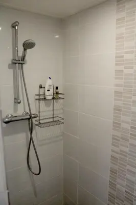 a bathroom with a shower with a shower head at Houseboat Linquenda in Woubrugge