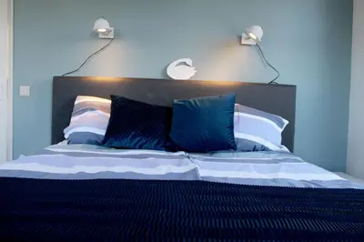 a bedroom with a bed with two lights on the wall at Houseboat Linquenda in Woubrugge