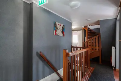 a hallway with stairs and a painting on the wall at Alex Rooms in Zwanenburg
