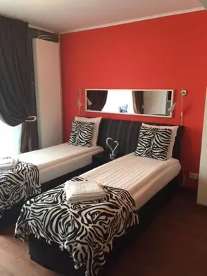 two beds in a room with red walls at Alex Rooms in Zwanenburg