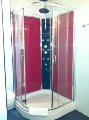 a glass shower in a bathroom with a toilet at Alex Rooms in Zwanenburg