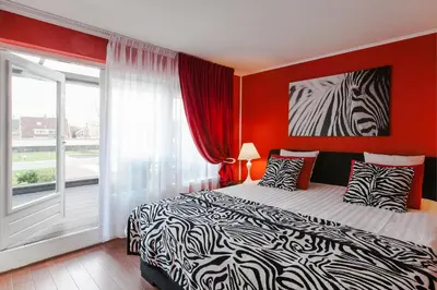 a bedroom with a bed and a large window at Alex Rooms in Zwanenburg