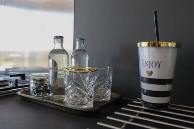 a tray with bottles and glasses and a cup on a table at Chill-out in Nieuwe Wetering