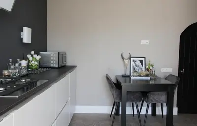 a kitchen with a black counter top with a table at Chill-out in Nieuwe Wetering