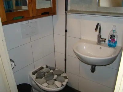 a bathroom with a sink and a bowl of rocks at Amsterhouse B&B in Amsterdam