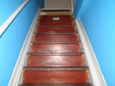 a flight of wooden stairs in a blue room at Amsterhouse B&B in Amsterdam