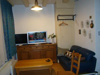 a living room with a couch and a television on a cabinet at Amsterhouse B&B in Amsterdam