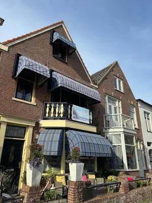 a building with an awning on the front of it at B&B de Zandtaart in Egmond aan Zee