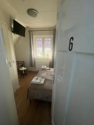 a small room with a bed and a window at B&B de Zandtaart in Egmond aan Zee