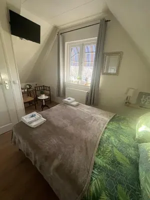 a bedroom with a bed with two towels on it at B&B de Zandtaart in Egmond aan Zee