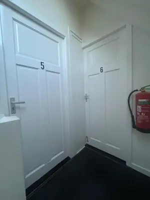 two white doors in a room with a fire hydrant at B&B de Zandtaart in Egmond aan Zee