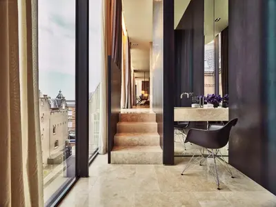 a room with a staircase and a table with a chair at Mandarin Oriental Conservatorium, Amsterdam in Amsterdam