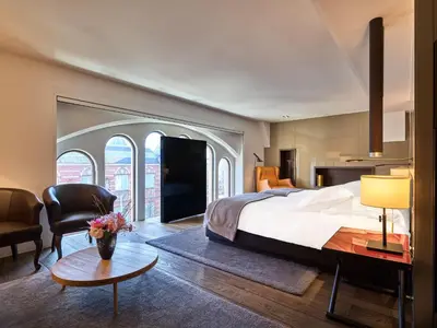 a bedroom with a large bed and a living room at Mandarin Oriental Conservatorium, Amsterdam in Amsterdam