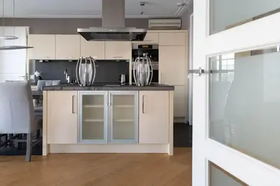 a kitchen with white cabinets and a counter top at Appartement Volendam in Volendam