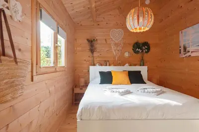 a bedroom with a white bed in a wooden room at The Sea Lodge in Zandvoort