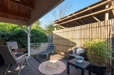 a patio with a pergola and a table and chairs at The Sea Lodge in Zandvoort