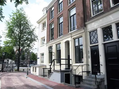 a building on a street with a tree in front of it at Amsterdam Canal Guest Apartment in Amsterdam