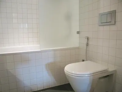 a white toilet in a bathroom with white tiles at Amsterdam Canal Guest Apartment in Amsterdam