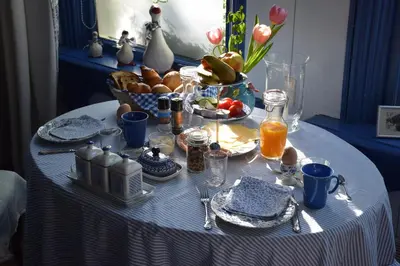 a table with a blue and white table cloth with food and drinks at Het Twiscker Huys in Twisk