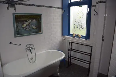 a bathroom with a white tub and a window at Het Twiscker Huys in Twisk