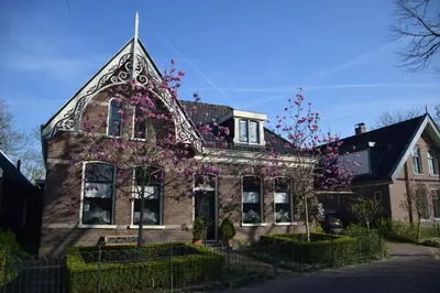 an old brick house with flowers on it at Het Twiscker Huys in Twisk