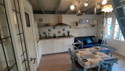 a kitchen and a dining room with a table and a kitchen at Close to the beach in Wijk aan Zee