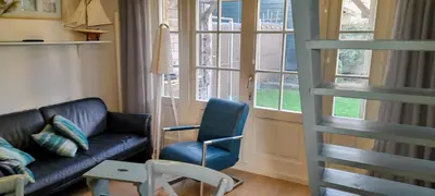a living room with a couch and a chair at Close to the beach in Wijk aan Zee