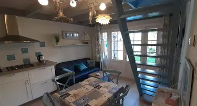 a kitchen and a living room with a table and a staircase at Close to the beach in Wijk aan Zee