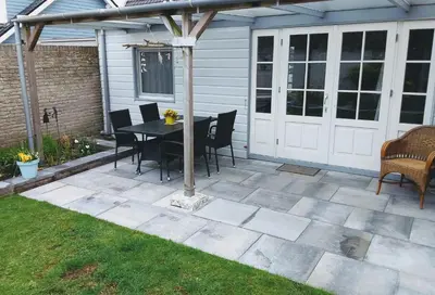 a patio with a table and chairs and a fence at Close to the beach in Wijk aan Zee