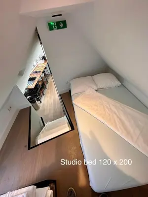 an attic room with a mirror and a bed at Appartementen in het centrum van Hoorn in Hoorn