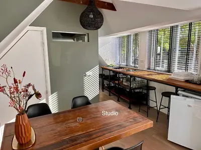 a dining room with a table and chairs and windows at Appartementen in het centrum van Hoorn in Hoorn