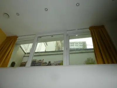 a window with yellow curtains in a room at The Old Lady in Amsterdam