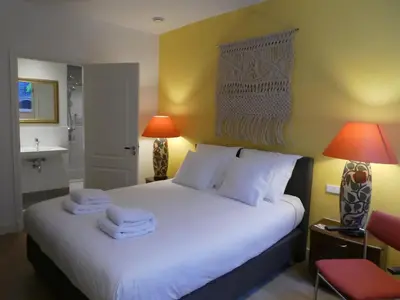 a bedroom with a large white bed with two lamps at The Old Lady in Amsterdam