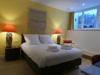 a bedroom with a large bed with two lamps at The Old Lady in Amsterdam