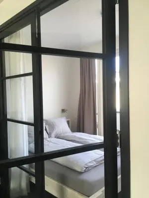 a bed is seen through a glass window at Pakhuis 5 in Katwijk aan Zee
