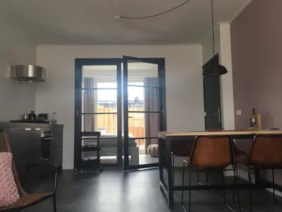 a room with a kitchen with a table and chairs at Pakhuis 5 in Katwijk aan Zee