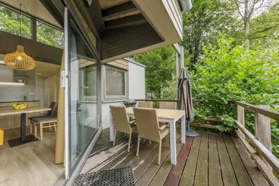 a screened in porch with a table and chairs at Center Parcs De Eemhof in Zeewolde