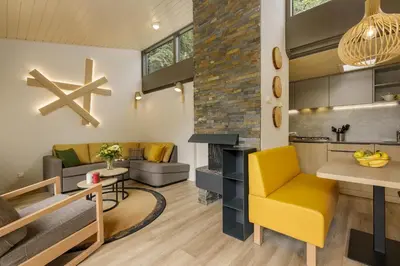 a living room with a yellow chair and a couch at Center Parcs De Eemhof in Zeewolde